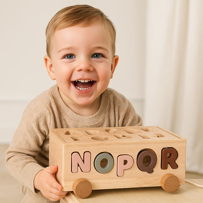 Bambino gioca con macchinina dell’alfabeto nei giochi in legno, apprendimento delle lettere divertente e sicuro.